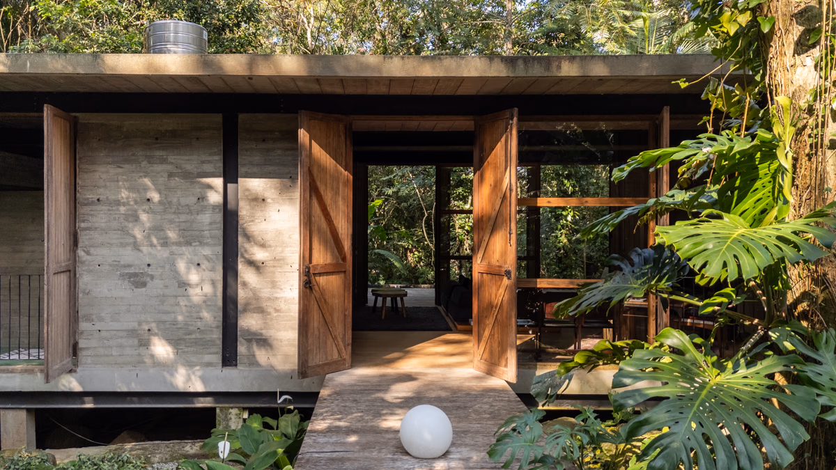 Casa Jabuti, Studio Carlito e Renata Pascucci. Fachada em concreto e madeira aberta para a mata.